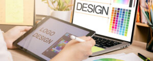 Designer working on logo on tablet and laptop